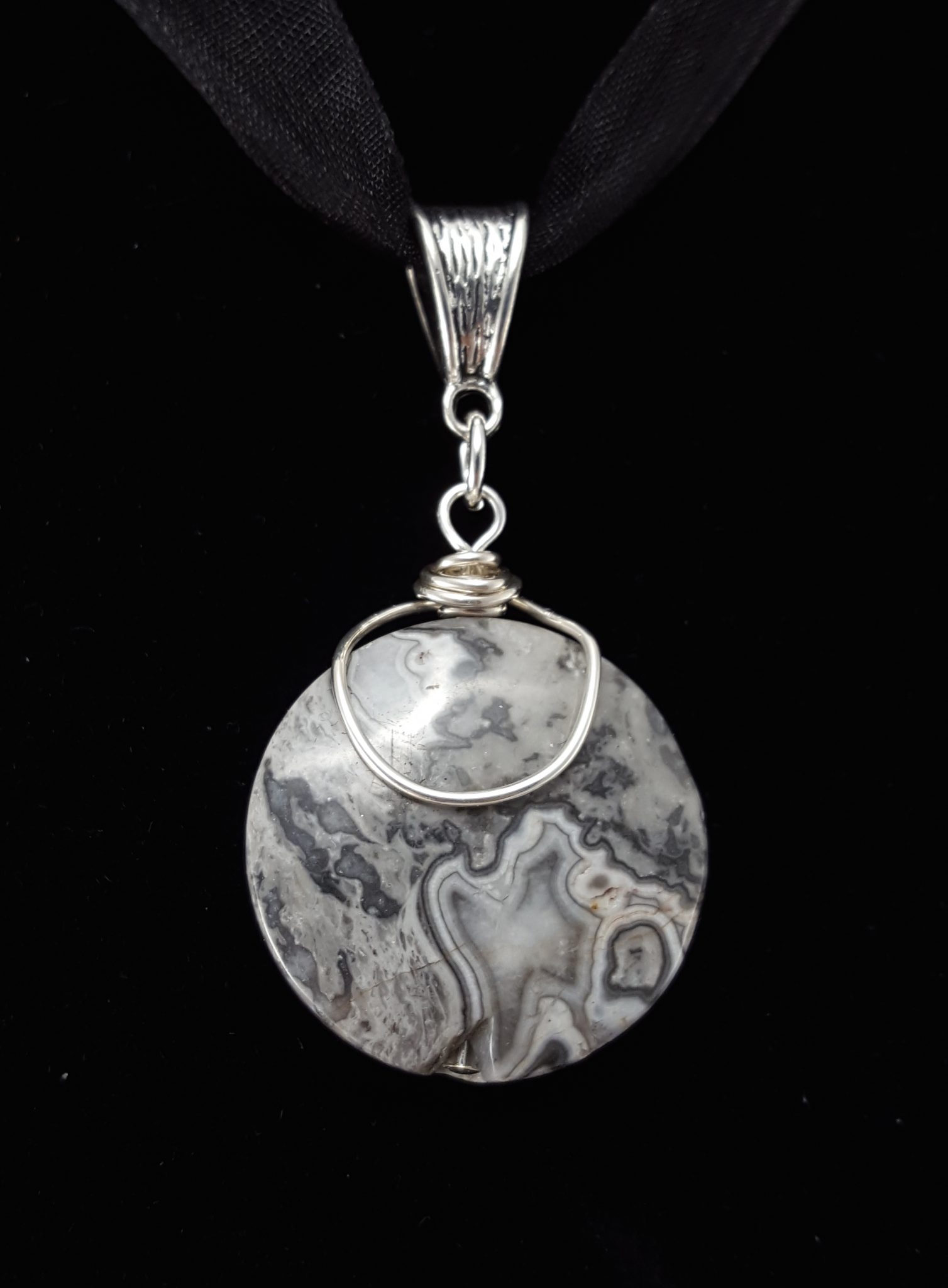 Crazy lace agate wire wrapped pendant in sterling silver plated wire